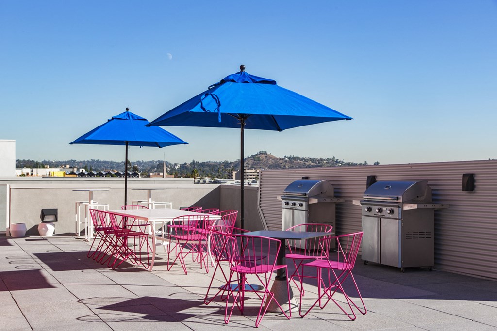 a patio with tables and chairs and umbrellas on a roof