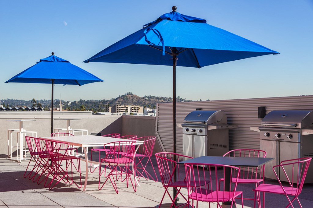 a patio with tables and chairs and umbrellas on top of a roof
