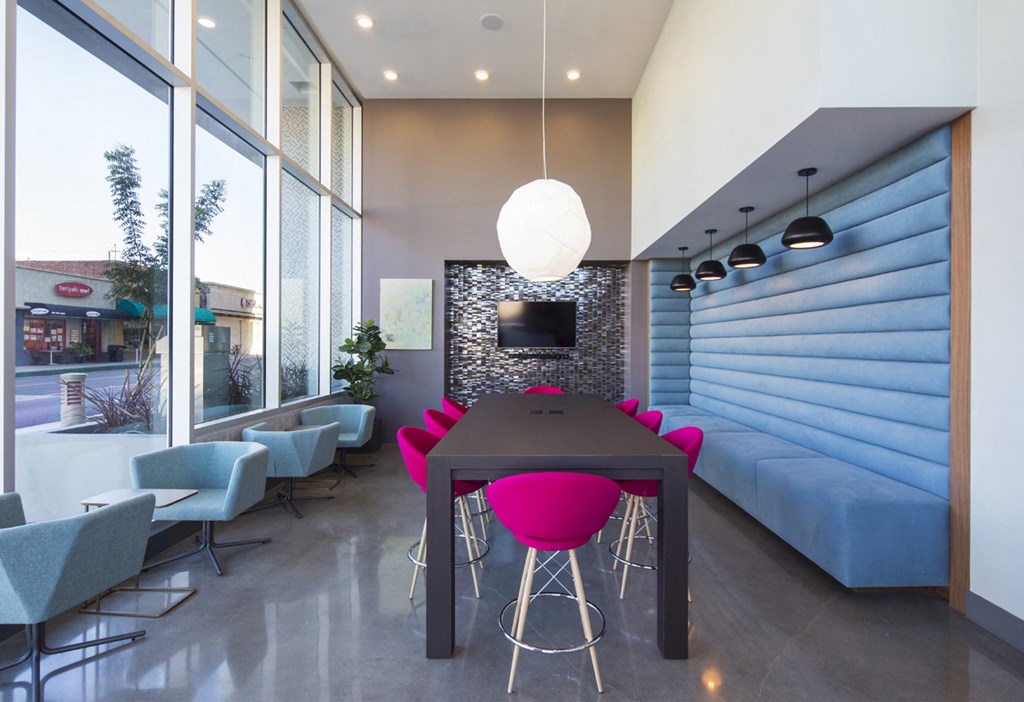 a dining room with a black table and pink chairs