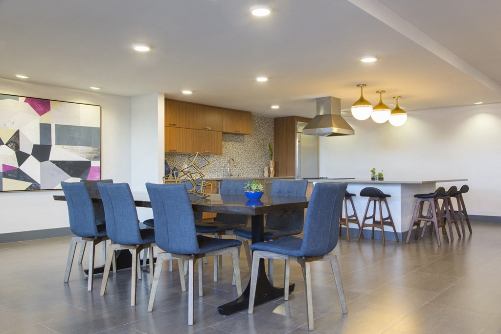 a dining room and kitchen with blue chairs and a table