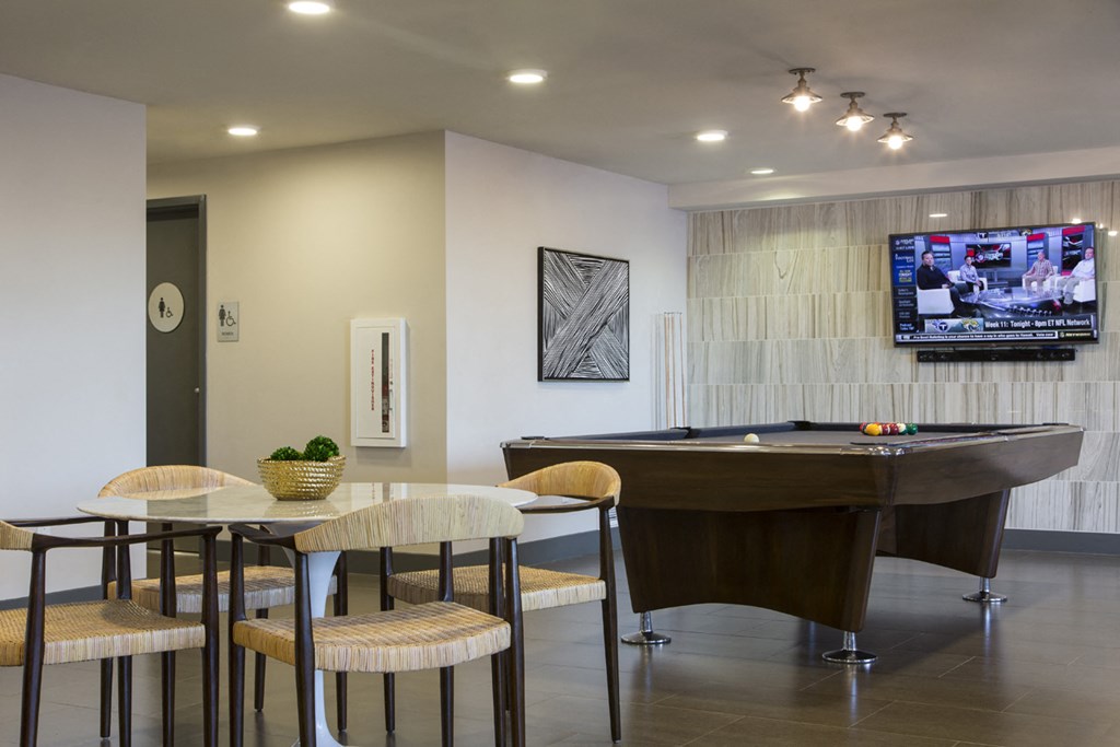 a living room with a pool table and a tv