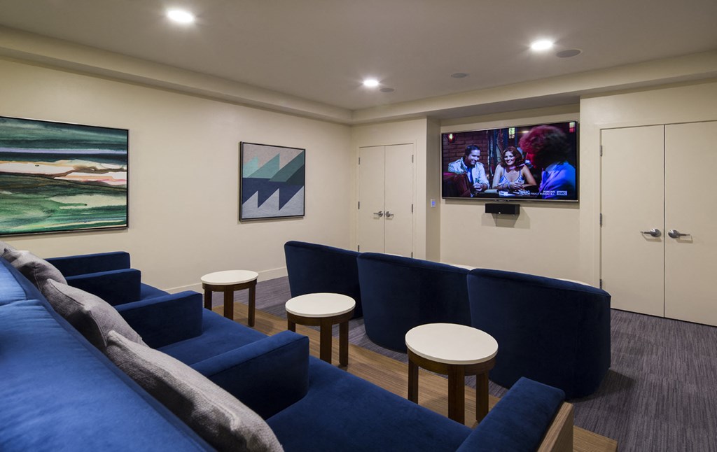 a living room with blue couches and a television