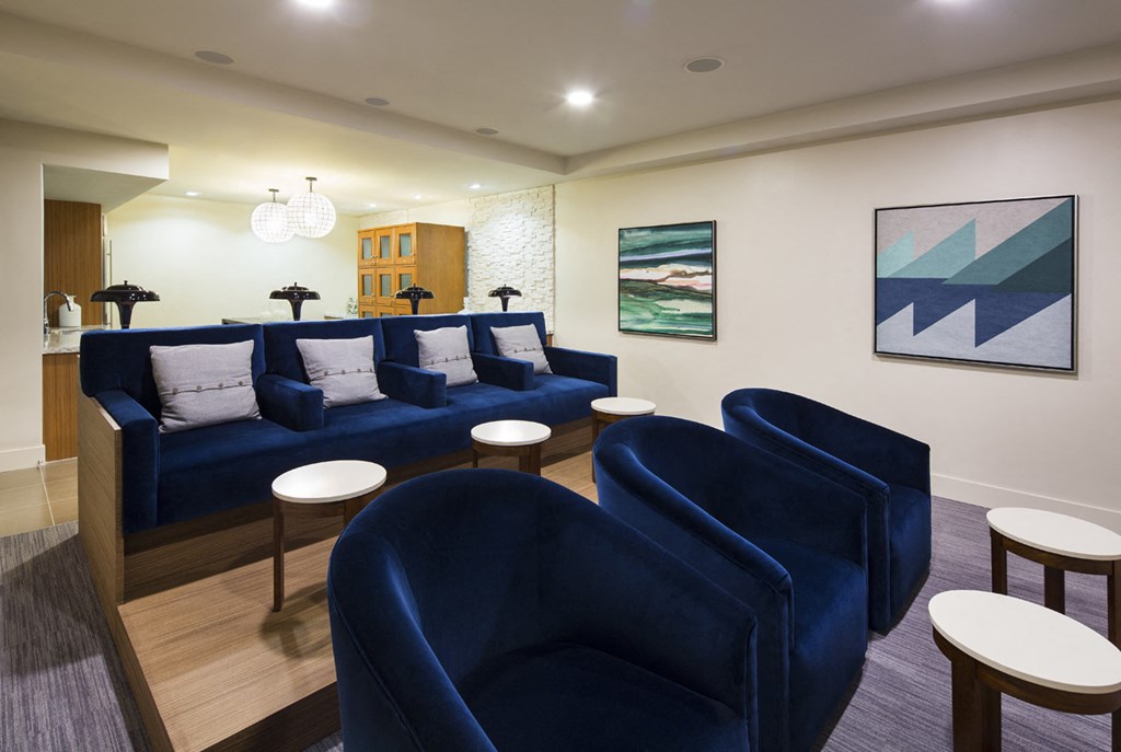 a living room with blue couches and chairs