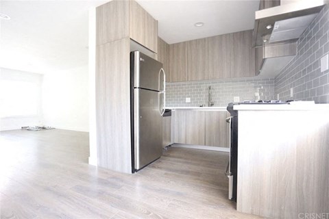 an empty kitchen with a stainless steel refrigerator