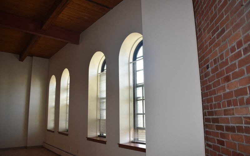 a row of windows in a room with a brick wall