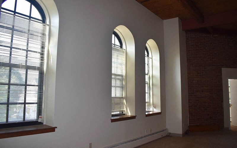 three windows in an empty room with blinds on them