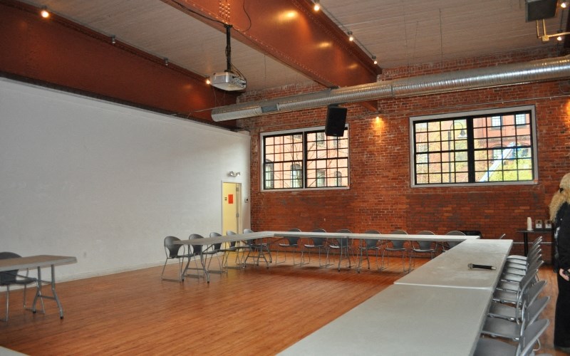 a large room with a row of tables and chairs and a projector