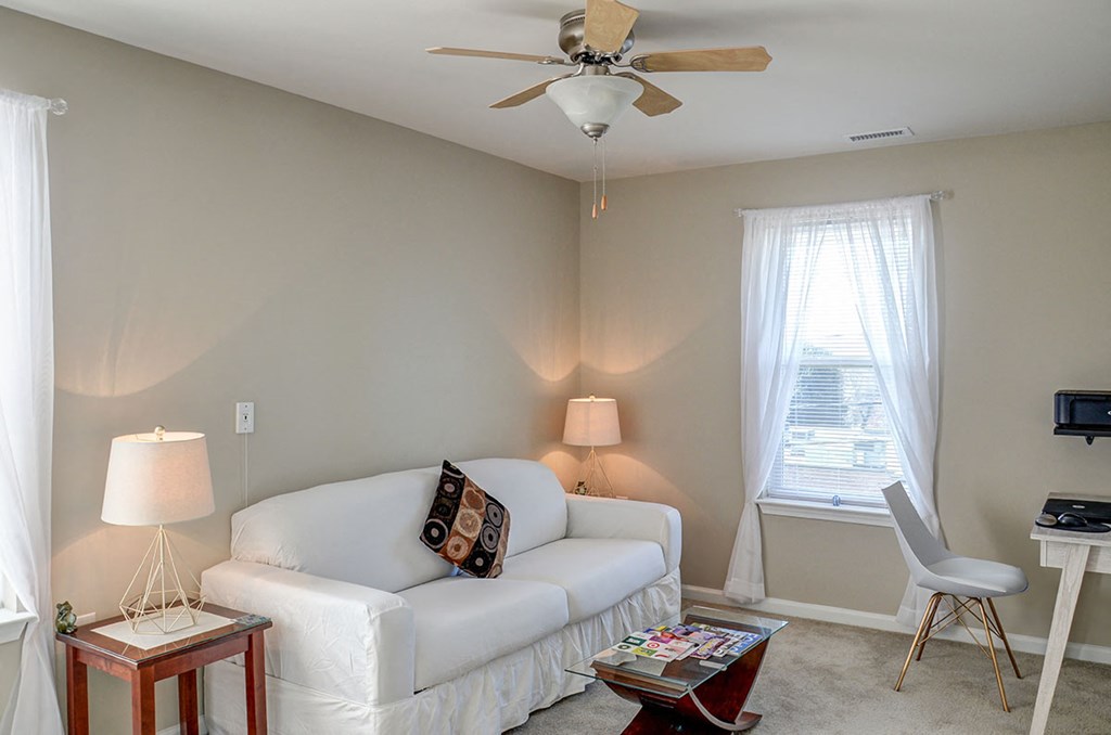 a living room with a couch and a ceiling fan