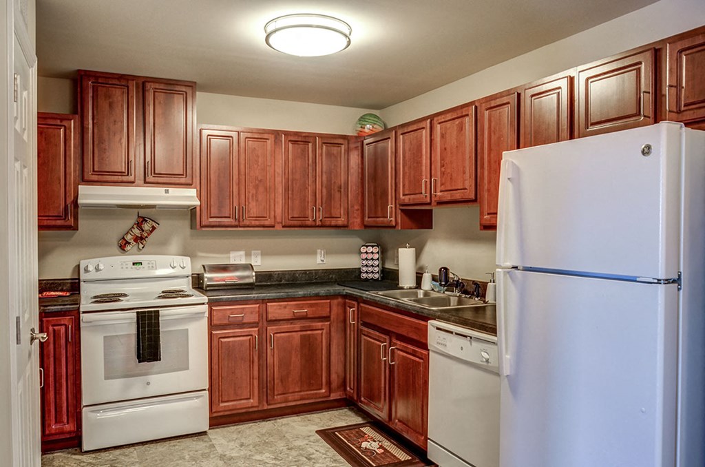 a kitchen with white appliances and wooden cabinets