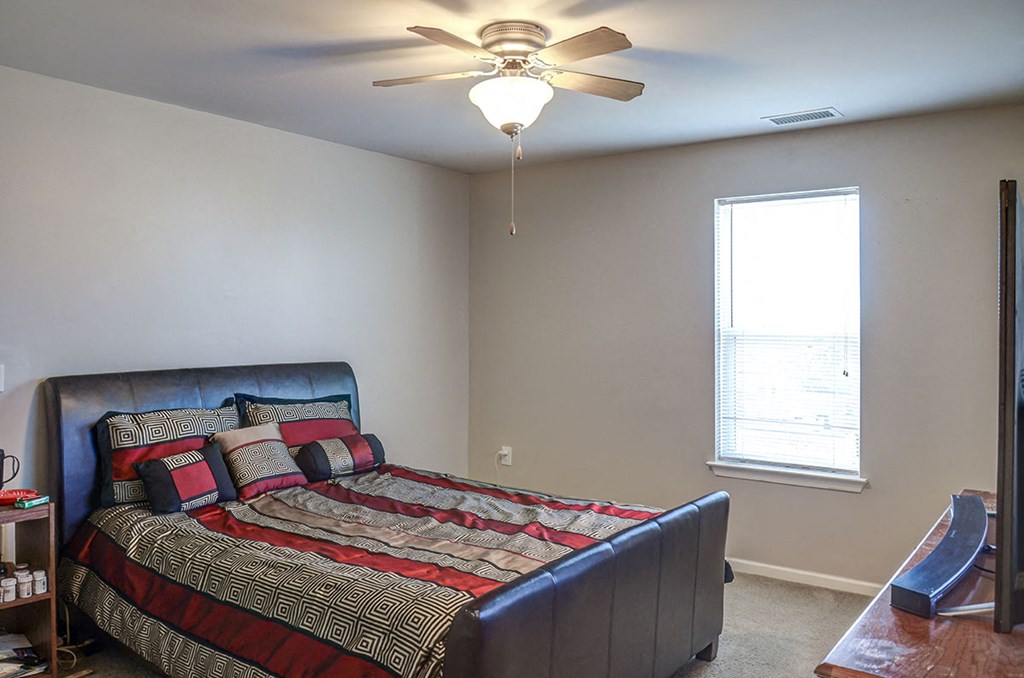 a bedroom with a bed and a ceiling fan