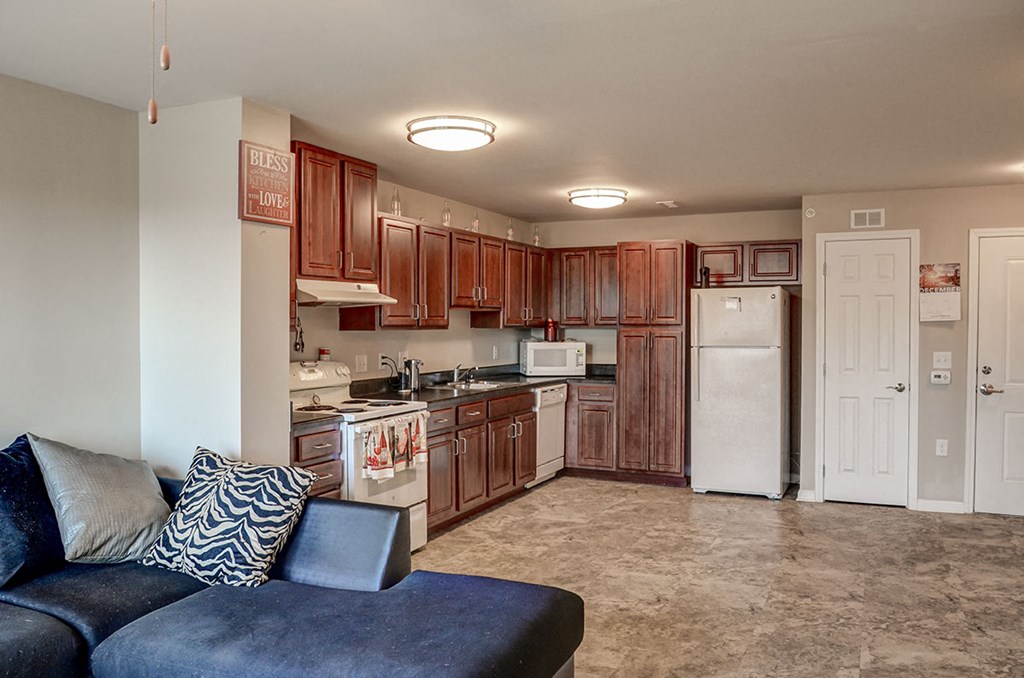 a kitchen with wooden cabinets and a blue couch