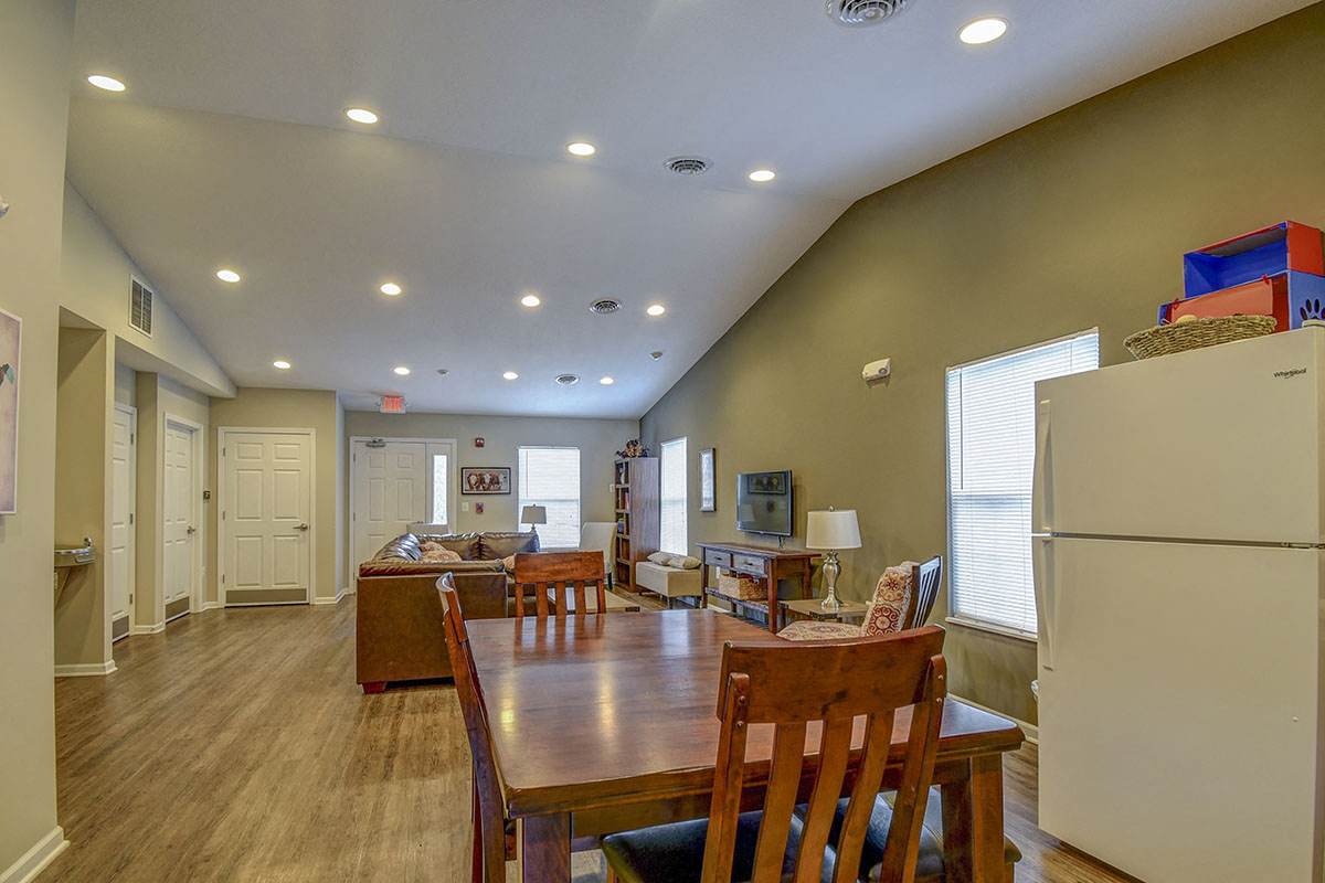 a dining room and living room with a table and refrigerator