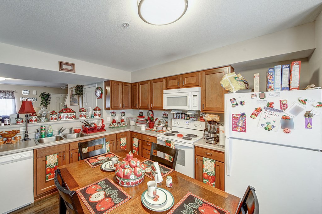 a kitchen with a wooden table and a white refrigerator