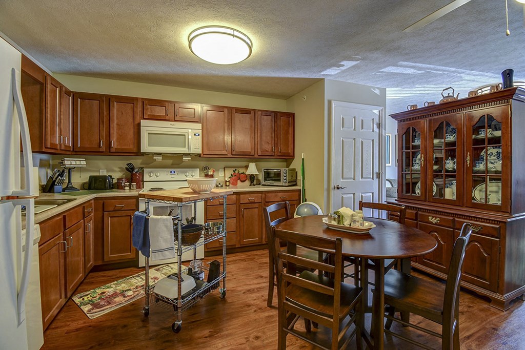 a kitchen with wooden cabinets and a wooden table