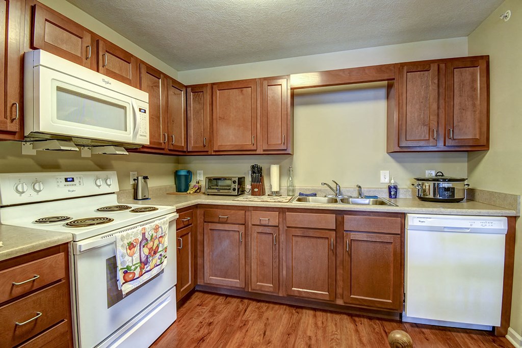 a kitchen with white appliances and wooden cabinets
