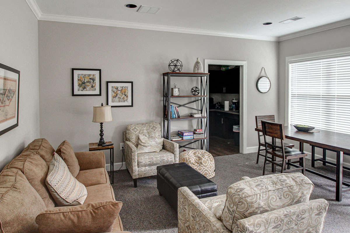 a living room with couches and chairs and a dining room table