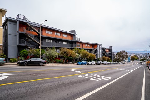 a city street with cars parked in front of a building