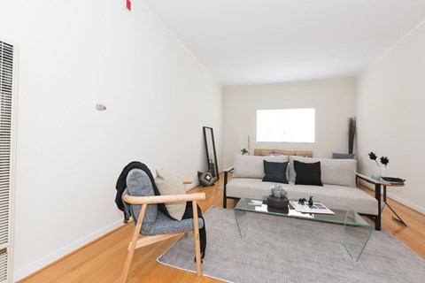 A living room with a grey couch, a chair, and a coffee table.