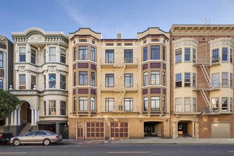 A row of three-story apartment buildings with garages on the ground floor.