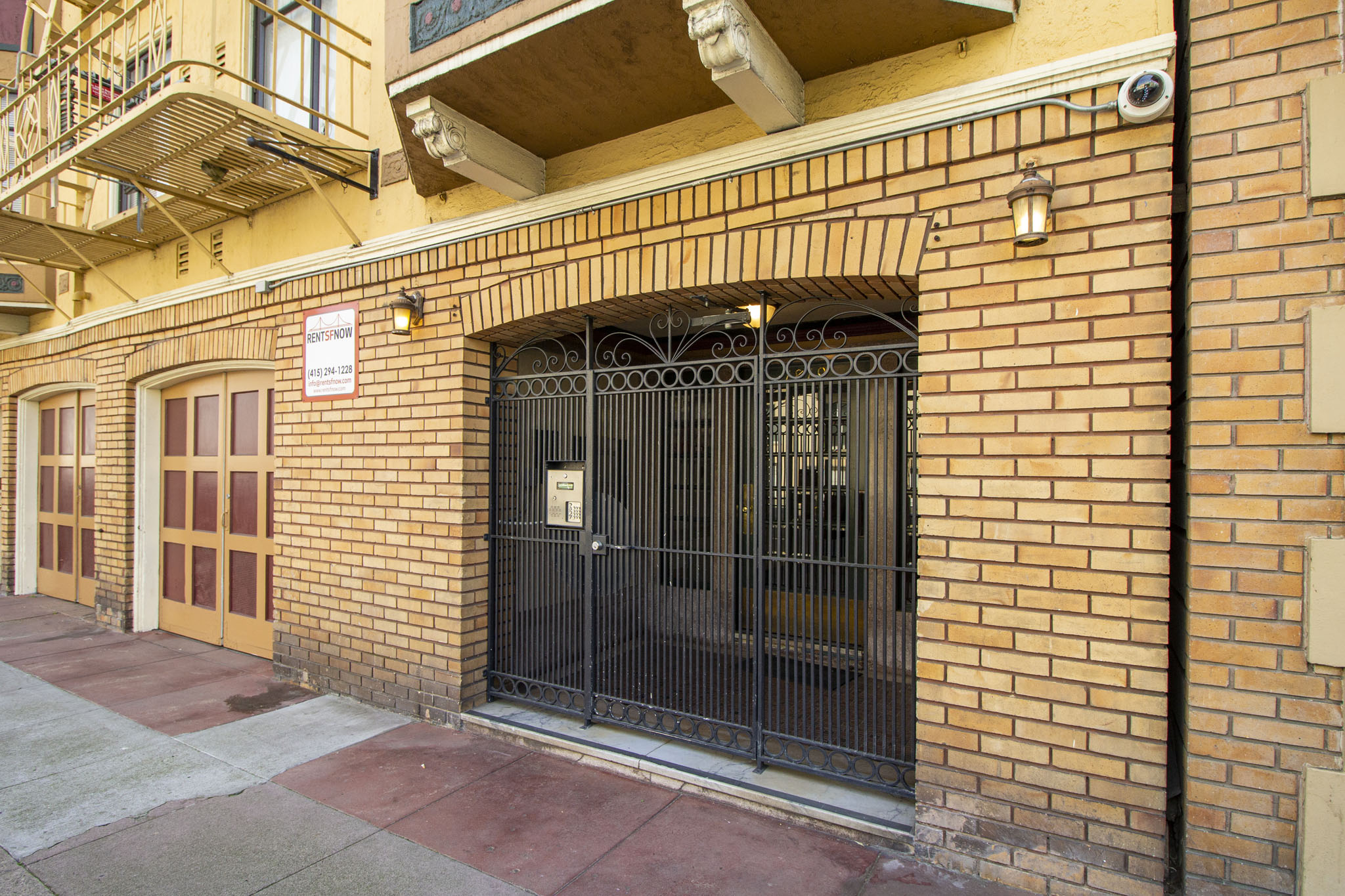 A black gate is on a brick wall.