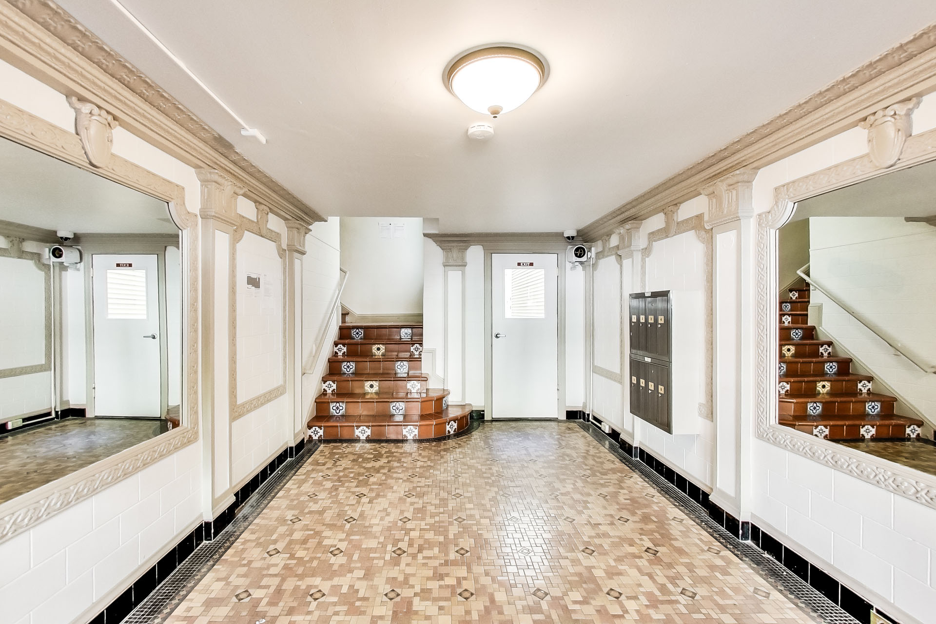 A hallway with a staircase and a tiled floor.
