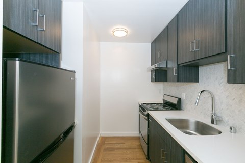 A kitchen with a stainless steel refrigerator and a sink.