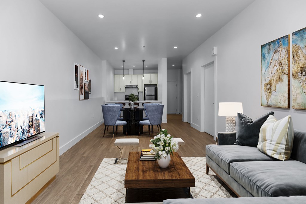 A modern living room with a grey sofa, a wooden coffee table, and a television on a cabinet.