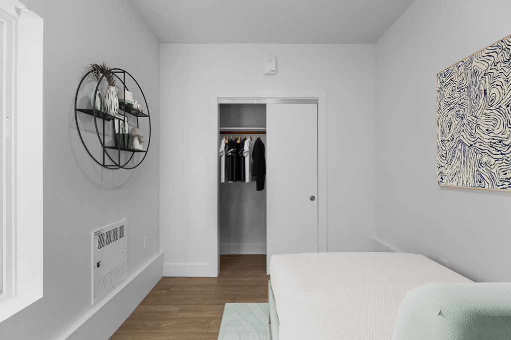 A white room with a round wall hanging and a white couch.