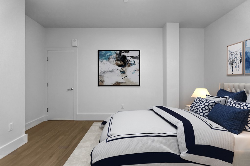 A bedroom with a large bed and a painting on the wall.