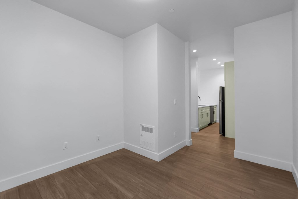 A room with white walls and wooden flooring.