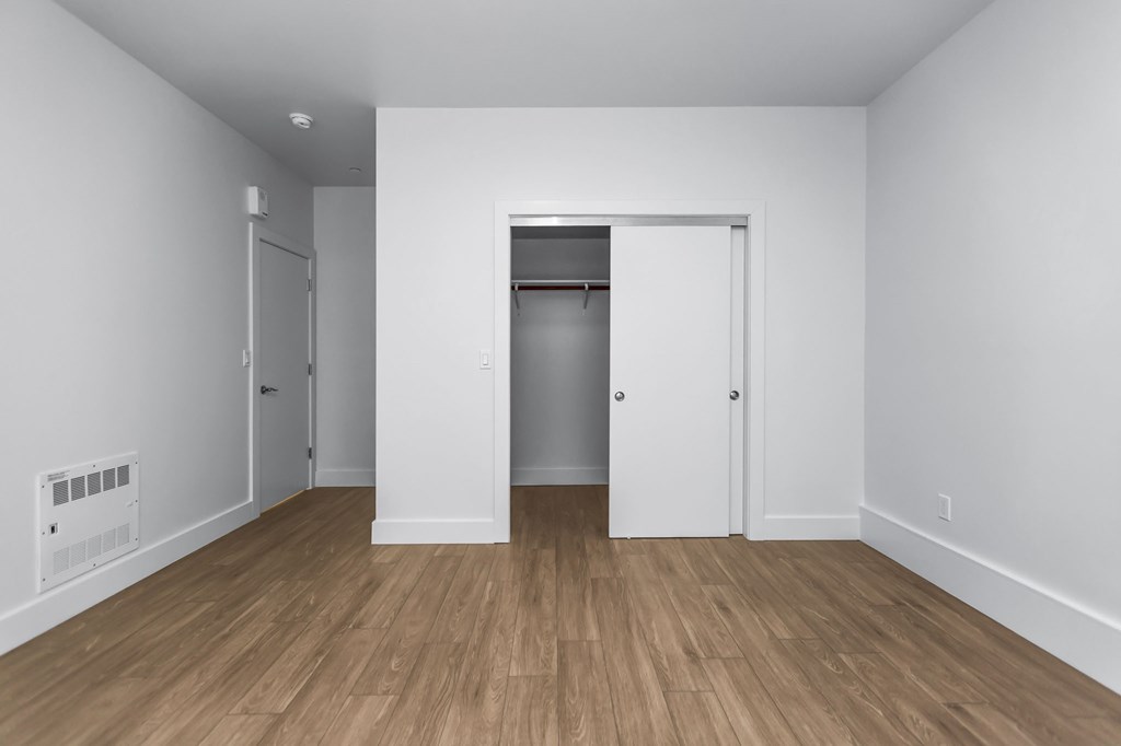 A room with a white wall and a wooden floor.