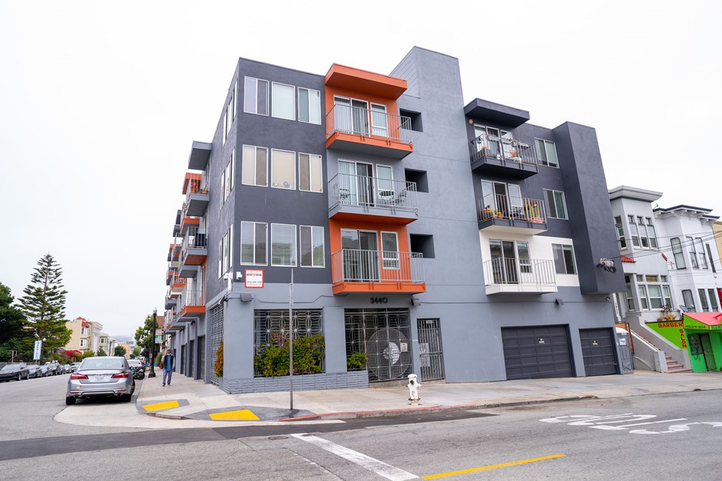 A modern multi-story building with balconies and a grey facade.