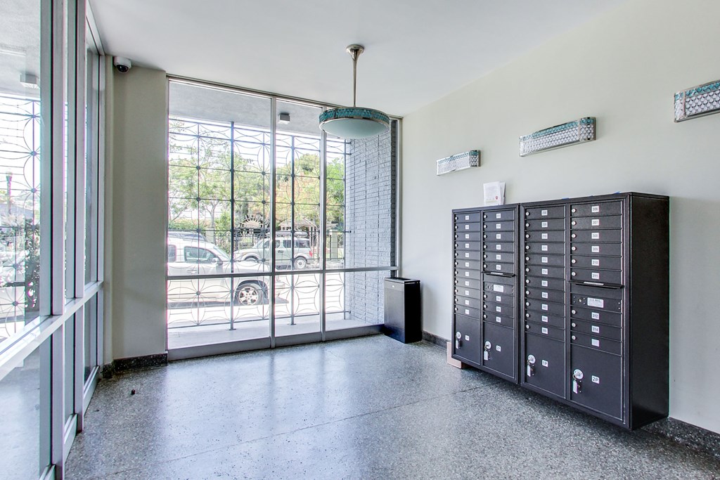A room with a black filing cabinet and a glass door leading to a parking lot.