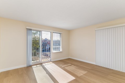 A room with a sliding glass door leading to a balcony.