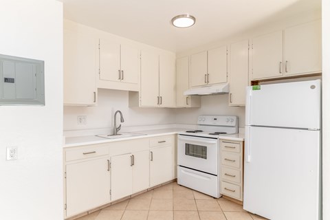 A kitchen with white appliances and cabinets.
