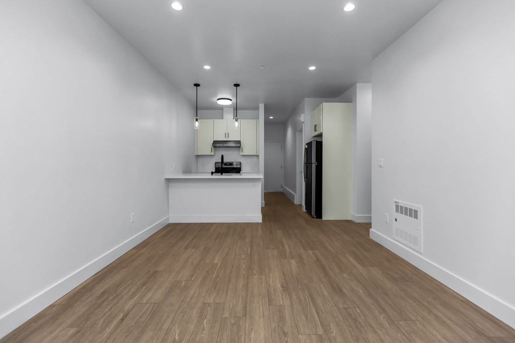 A long hallway with a kitchen area at the end.