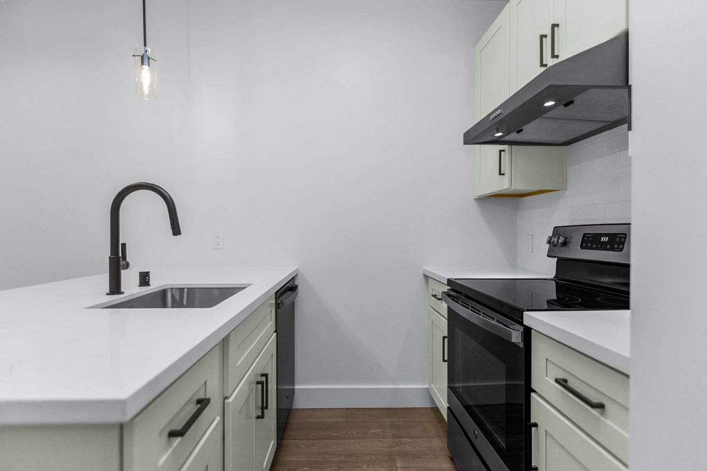 A kitchen with a black faucet and a black oven.