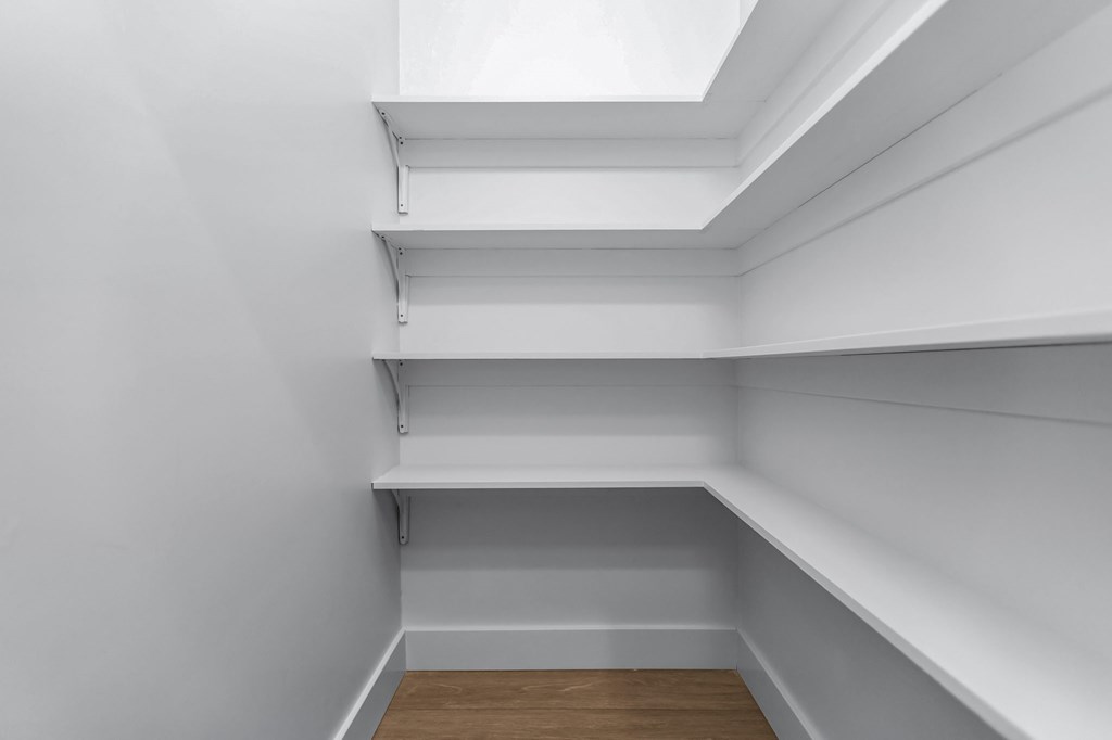 Empty white room with shelves and a skylight.