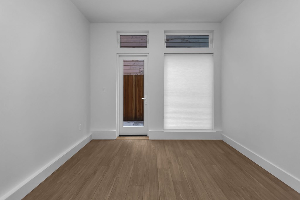 A room with a wooden floor and a brown door.