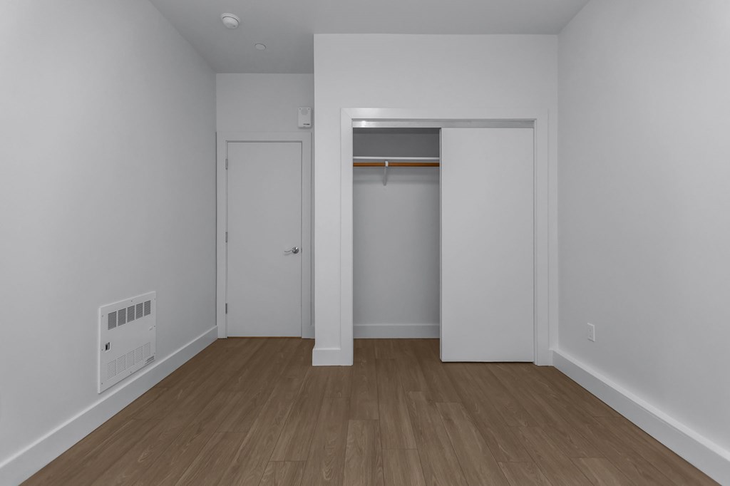 A room with a white wall and a wood floor.