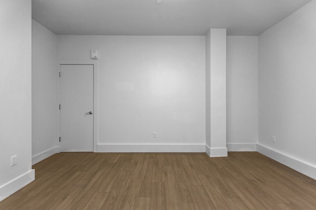 A room with a white door and a white column.