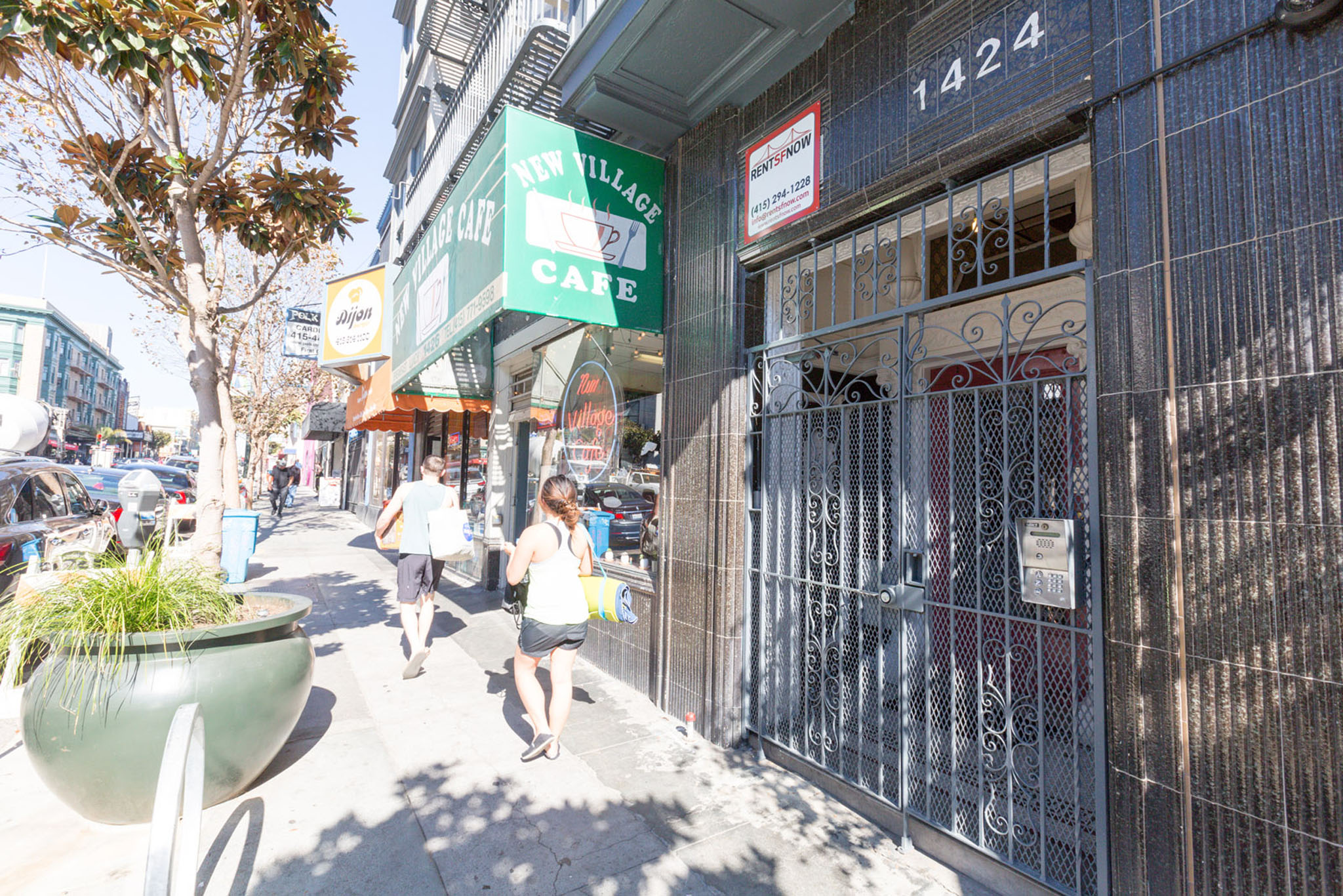 A street view with people walking and a closed cafe.