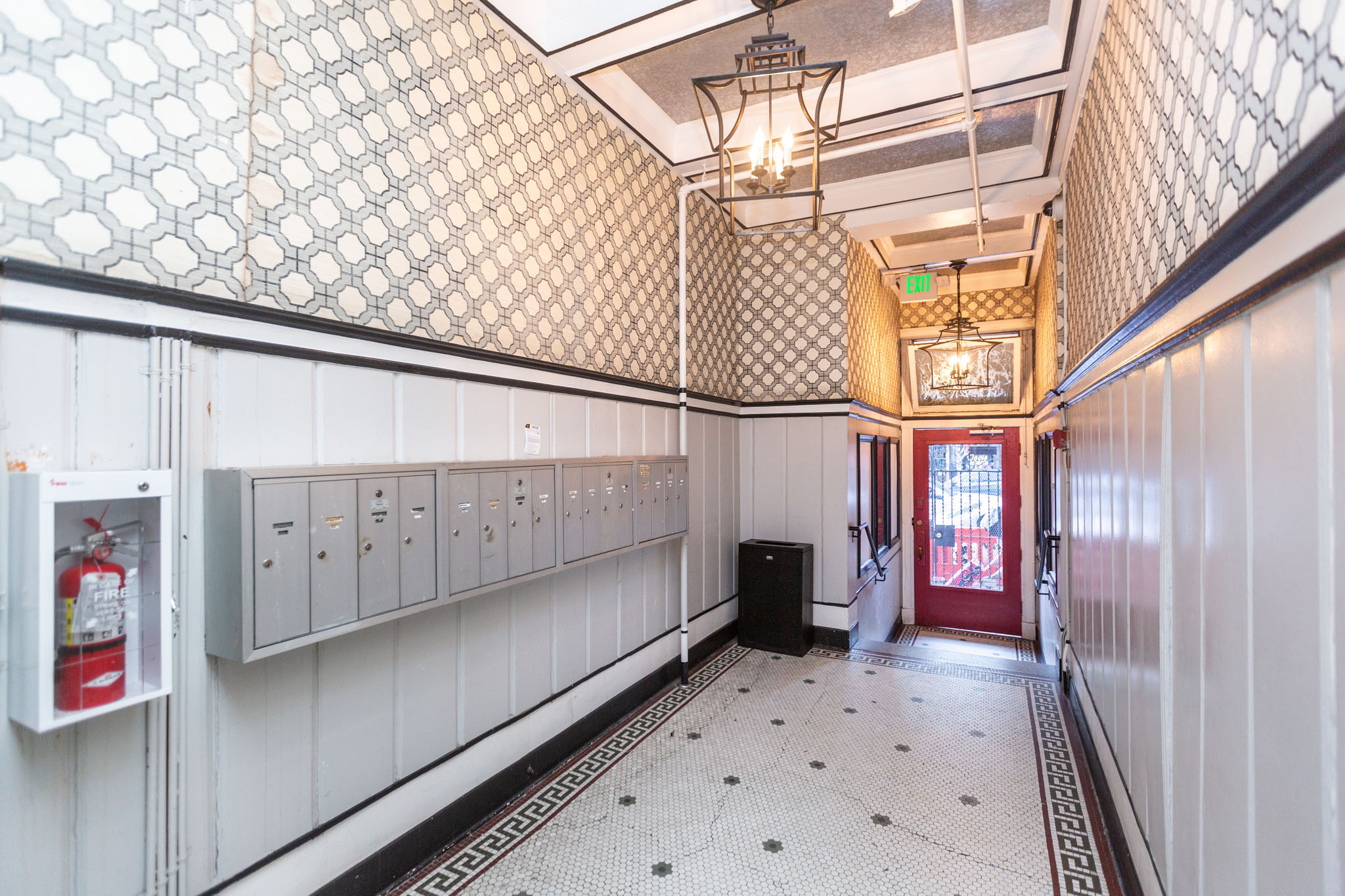 A hallway with a red door at the end.