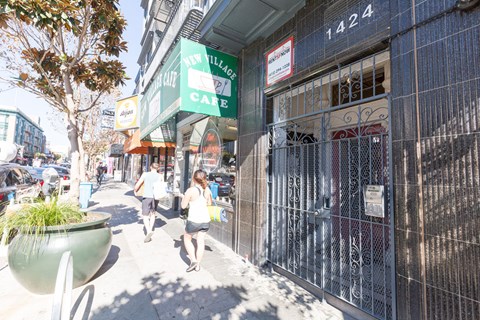 A street view with people walking and a closed cafe.