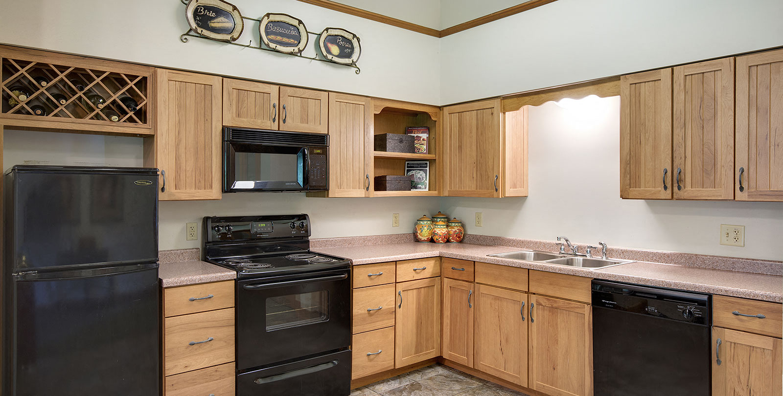 A kitchen with wooden cabinets and black appliances.