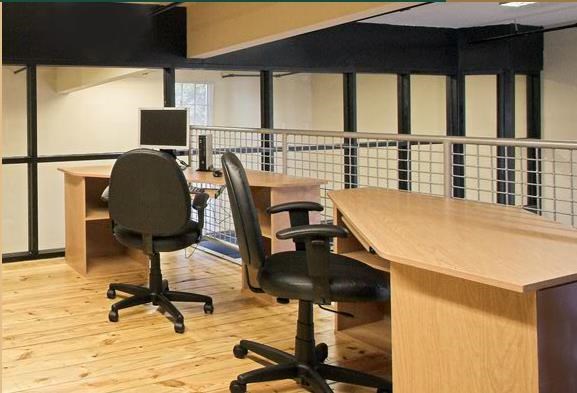 a conference room with desks and chairs and a computer