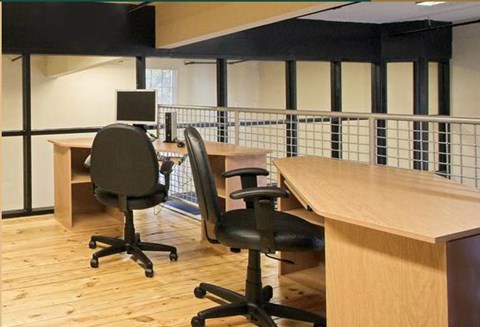 a conference room with desks and chairs and a computer