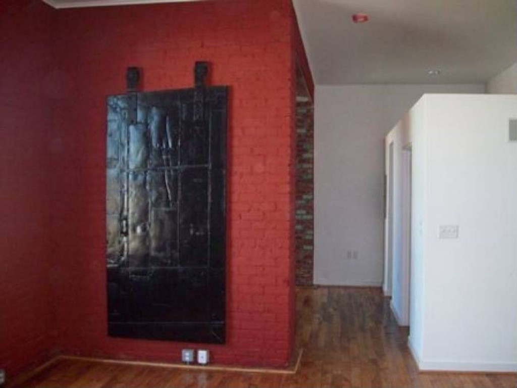 a red brick wall with a black painting on it
