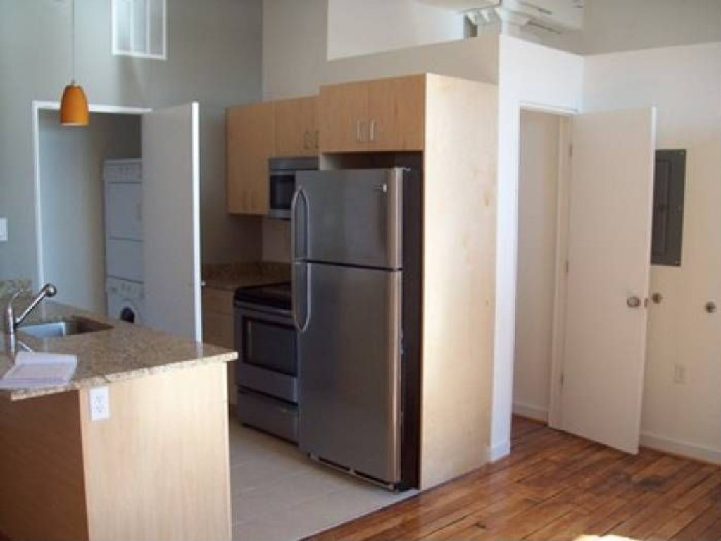 an empty kitchen with a stainless steel refrigerator