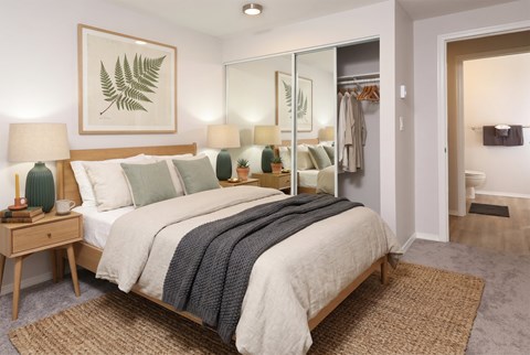 A bedroom with a large bed and a mirror on the wall.